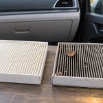 Чистый и загрязнённый складчатые салонные фильтры рядом с автомобильной панелью