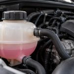 Расширительный бачок охлаждающей жидкости с закрытой крышкой под капотом