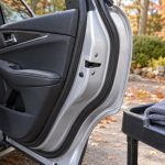Чистый резиновый уплотнитель открытой двери автомобиля рядом с салфеткой