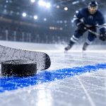 Шайба и крюк хоккейной клюшки возле синей линии на льду