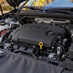 Моторный отсек автомобиля с жёлтой ручкой масляного щупа и чистой салфеткой